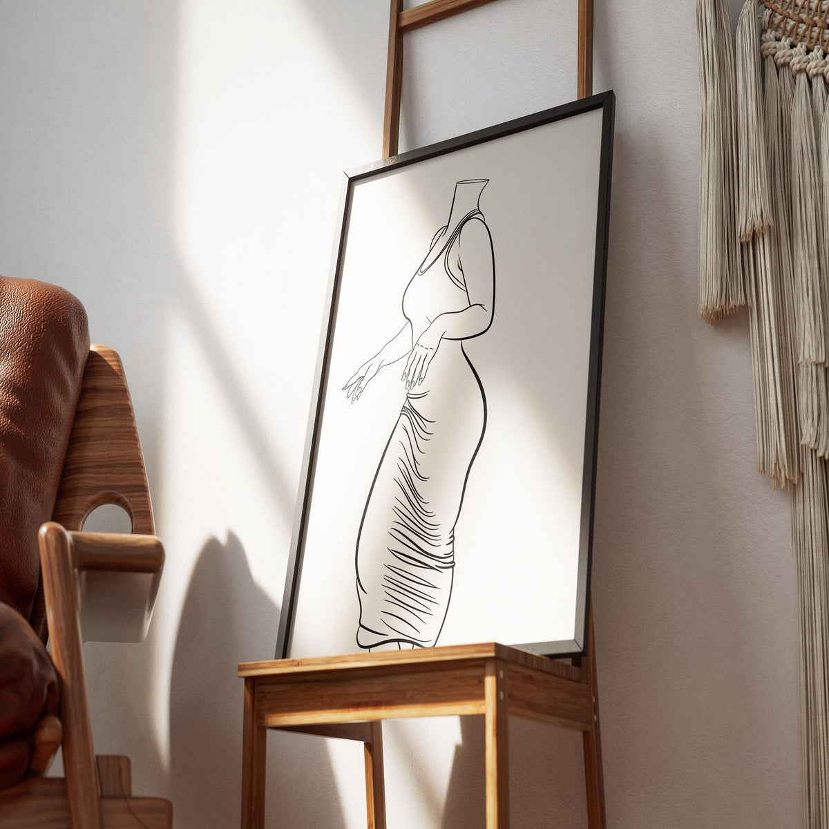 Line art illustration of a form-fitting dress, elegantly framed, displayed on an easel in a cozy room setting.